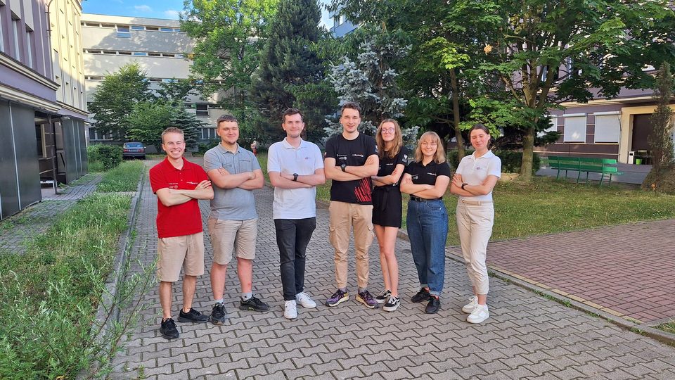 Zdjęcie grupowe zespołu PMG i przedstawicieli PWR Racing Team na kampusie